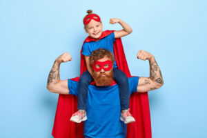 Imagem de um pai vestido de super herói com sua filha